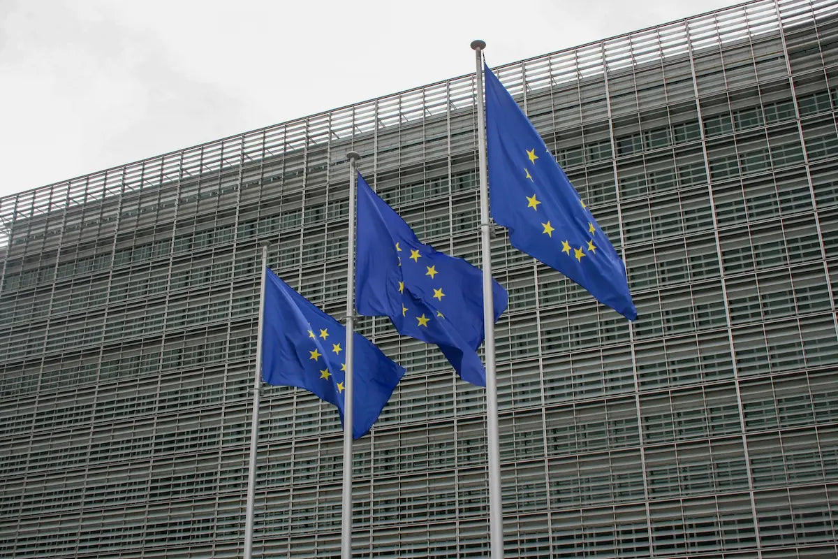 Drapeaux de l'Union européenne devant la Commission européenne à Bruxelles, symbole du règlement AI Act sur le recrutement
